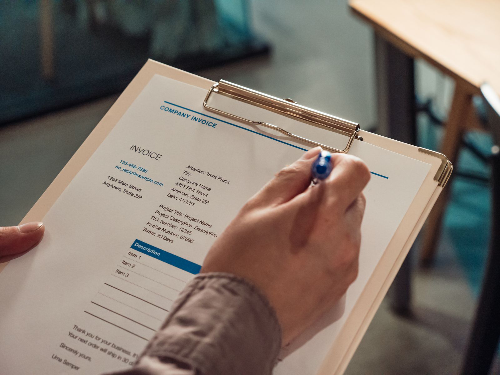Invoice paperwork being reviewed on a clipboard for receipts and reports